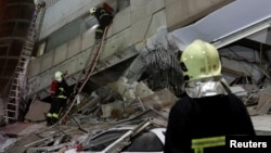 A fireman works at a collapses building after earthquake hit Hualien, Taiwan, Feb. 7, 2018.