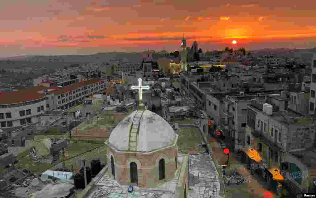 A view shows the dome of the Assyrian church facing a mosque minaret at Manger Square where the Church of the Nativity is located, in Bethlehem in the Israeli-occupied West Bank.
