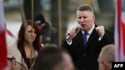 FILE - Paul Golding (R) and Jayda Fransen (L), leaders of the far-right organisation Britain First, talk during a march in central London on April 1, 2017.