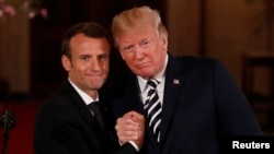 French President Emmanuel Macron clasps hands with U.S. President Donald Trump at the conclusion of their joint news conference in the East Room of the White House in Washington, April 24, 2018.