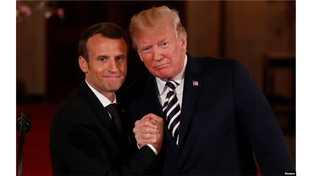 French President Emmanuel Macron clasps hands with President Donald Trump at the conclusion of their joint news conference in the East Room of the White House in Washington, April 24, 2018.