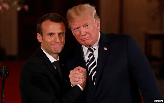 French President Emmanuel Macron clasps hands with U.S. President Donald Trump at the conclusion of their joint news conference in the East Room of the White House in Washington, April 24, 2018.