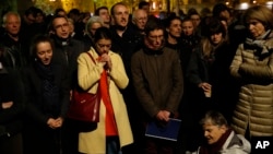 People pray as Notre Dame cathedral is burning in Paris, April 15, 2019.