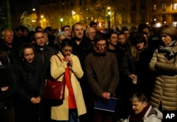 People pray as Notre Dame cathedral is burning in Paris, Monday, April 15, 2019.