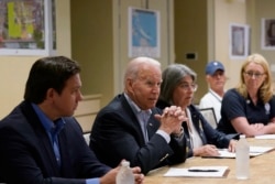 President Joe Biden, second from left, flanked by Florida Gov. Ron DeSantis, left, and Incident Commander Mayor Daniella Levine Cava, third from left, speaks during a briefing with first responders and local officials in Miami Beach, Fla.