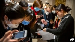 带着口罩的记者们阅读中国政府有关新冠病毒的声明(2020年1月26日资料照片)