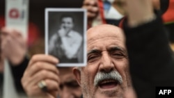 A man holds a picture of Selahattin Demirtas as people gather outside Bakirkoy courthouse in Istanbul, Jan. 12, 2018, in support of the jailed co-chair of the People's Democratic Party (HDP). 