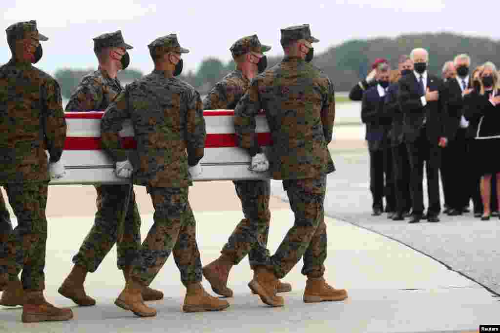 U.S. President Joe Biden salutes during the dignified transfer of the remains of U.S. Military service members who were killed by a suicide bombing at the Hamid Karzai International Airport, at Dover Air Force Base in Dover, Delaware.