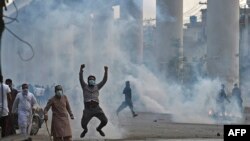 Polisi menggunakan gas air mata untuk membubarkan pendukung Tehreek-e-Labbaik Pakistan (TLP) selama protes di Lahore pada 12 April 2021, setelah penangkapan pemimpin mereka, yang menyerukan pengusiran duta besar Perancis. (Foto: AFP/Arif Ali)