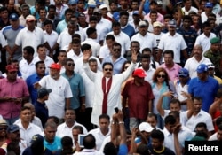Sri Lanka's former President Mahinda Rajapaksa waves at his supporters at the end of the five-day protest march from Kandy to Colombo, in Sri Lanka, Aug. 1, 2016.