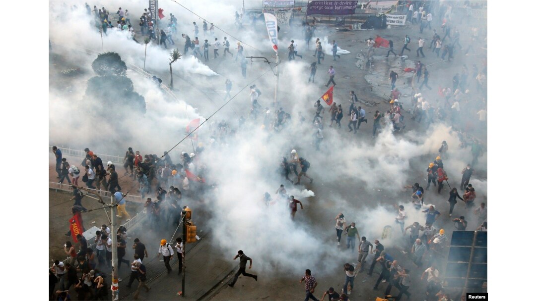 Protesters run in panic as riot police return to Istanbul's Taksim Square late afternoon and fire teargas canisters, in Istanbul, Turkey, June 11, 2013.