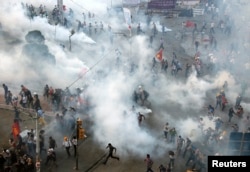 Protesters run in panic as riot police return to Istanbul's Taksim Square late afternoon and fire teargas canisters, in Istanbul, Turkey, June 11, 2013.