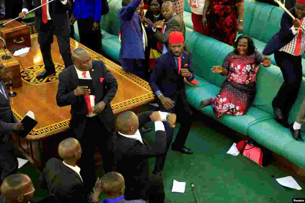 Ugandan opposition lawmakers fight with plainclothes security personnel in the parliament while protesting a proposed age limit amendment bill to change the constitution for the extension of the president's rule, in Kampala.