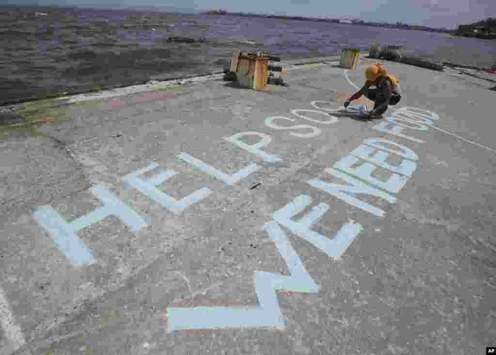 A survivor writes a call for help, Tacloban city, Leyte province, central Philippines, Nov. 11, 2013.