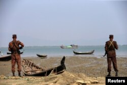 FILE - Members of Border Guard Bangladesh (BGB) stand guard on the bank of Naf River near the Bangladesh-Myanmar border to prevent Rohingya refugees from illegal border crossing, in Teknaf near Cox’s Bazar, Bangladesh, Nov. 22, 2016.