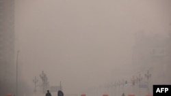 Khách bộ hành đi dọc theo một quảng trường ở Bắc Kinh. Dân chúng thủ đô này đang lên tiếng rằng giới hữu trách báo cáo không đúng sự thật về mức độ khói mù thường phủ trên bầu trời thủ đô