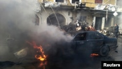 A man reacts near a burning car at the site of an explosion in the Shi'ite town of Hermel, Jan. 16, 2014. 