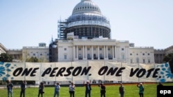 Supporters of the activist group 'Democracy Spring,' which have been staging protests for a week at the U.S. Capitol to 'end the corruption of big money in our politics and ensure free and fair elections,' gather for a rally on the West Lawn of the U.S. Capitol in Washington DC, USA, 15 April 2016. Several dozen activists were later arrested at a sit-in. EPA/JIM LO SCALZO