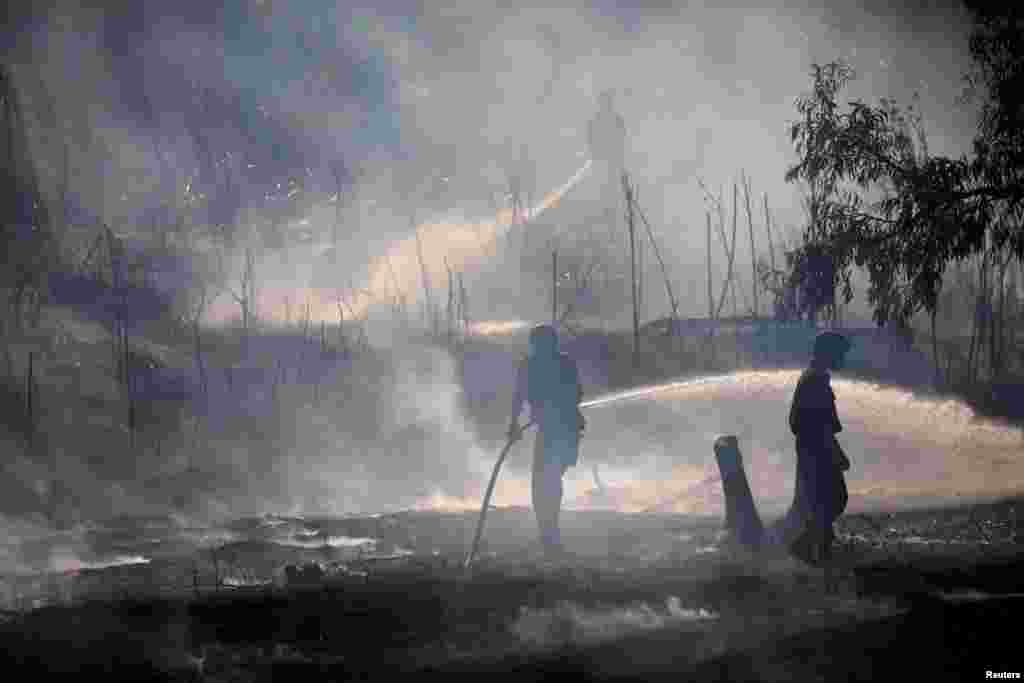 Israeli soldiers extinguish fire on the Israeli side of the border between Israel and Gaza.