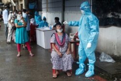 Seorang petugas medis tengah melakukan tes swab di Mumbai, India, 4 Juli 2020. (REUTERS/Francis Mascarenhas)