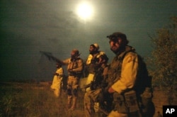 FILE - Members of the U.S. Army Special Forces watch the perimeter of a compound suspected of holding al-Qaida and Taliban forces during a raid.