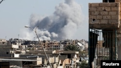 Smoke rises near the stadium where the Islamic State militants are holed up after an airstrike by coalition forces at the frontline, in Raqqa, Syria, Oct. 12, 2017.