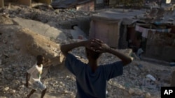 Children play at the rubble of earthquake-damaged houses in downtown Port-au-Prince, Haiti, 7 Jan 2011