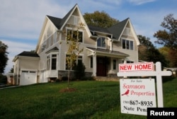 FILE - A real estate sign advertising a new home for sale is pictured in Vienna, Virginia, outside of Washington, Oct. 20, 2014.