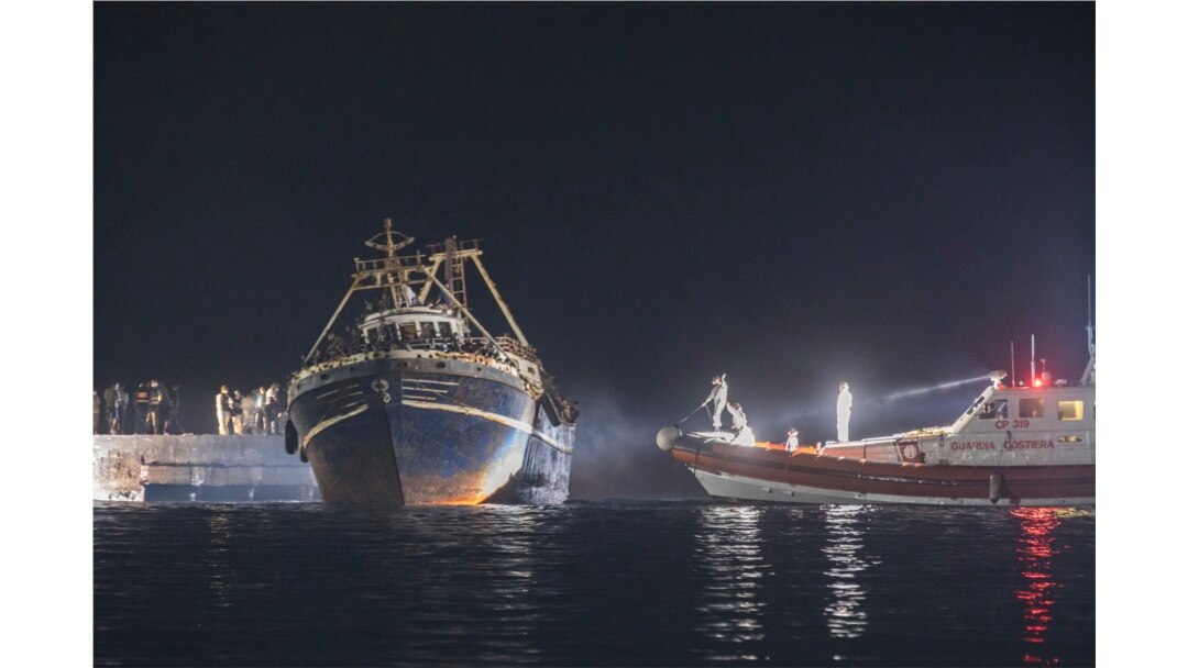 Sebuah kapal nelayan dengan para migran merapat di pelabuhan pulau Lampedusa Sisilia, Italia selatan, Senin malam, 27 September 2021.