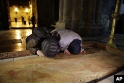 Visitors pray inside the Church of the Holy Sepulcher, traditionally believed by many Christians to be the site of the crucifixion and burial of Jesus Christ, in Jerusalem, Feb. 28, 2018.