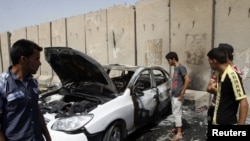 Residents gather at the site of a bomb attack in Baghdad June 16, 2012.