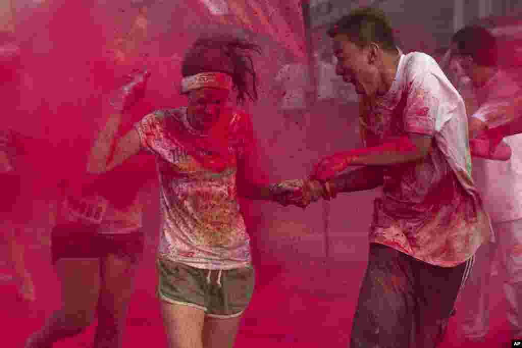 Runners go through a "color station" during a five-kilometer run in Beijing, China. Participants go through a "color station" every kilometer during the run.