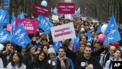 Para demonstran dari seluruh Perancis melakukan protes menentang legalisasi perkawinan sejenis di Paris dengan membawa poster: "Satu Ayah dan Satu Ibu" hari Minggu (13/1).