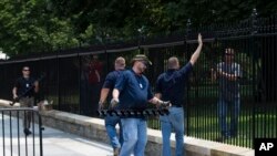 Des travailleurs installent une barrière dans l’enceinte de la clôture de la Maison Blanche après l’intrusion sans autorisation d’un homme, à Washington, 1er juillet 2015. 