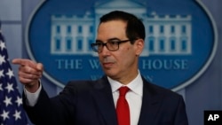 Treasury Secretary Steven Mnuchin points to a reporter to take a question during the news briefing at the White House, in Washington, Aug. 25, 2017. 