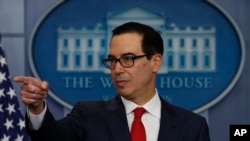 Treasury Secretary Steven Mnuchin points to a reporter to take a question during the news briefing at the White House, in Washington, Aug. 25, 2017. 