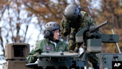 日本首相岸田文雄（左）在东京的一个军事基地检阅日本陆上自卫队10型坦克。（2021年11月27日）
