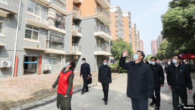 中国国家主席习近平在视察武汉一个居民区时向被隔离的居民招手致意。（2020年3月10日）