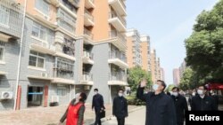 中國國家主席習近平在視察武漢一個居民區時向被隔離的居民招手致意。（2020年3月10日）