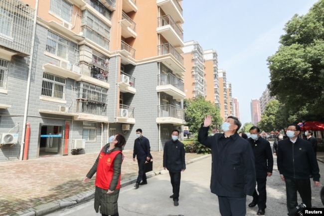 中国国家主席习近平在视察武汉一个居民区时向被隔离的居民招手致意。(2020年3月10日)