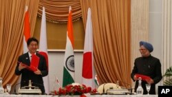 아베 신조(왼쪽) 일본 총리와 만모한 싱 인도 총리가 정상회담 뒤 양해각서를 교환하고 있다.