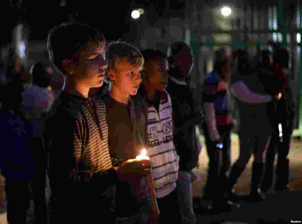 Boys hold a candle as they pay their respects outside the Mediclinic Heart Hospital, where ailing former South African President Nelson Mandela is being treated in Pretoria, July 1, 2013. 