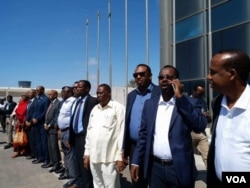 Somali officials line up at Mogadishu's airport to welcome Somali migrants from Libya, Feb. 17, 2018. (H.K. Qoyste/VOA)