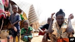 FILE - Refugees sit outside in an open area as there is lack of tents at the Dollo Ado refugee camp, Ethiopia.