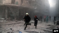 Nhân viên cứu hộ chạy tới khu vực bị không kích bằng bom thùng ở thành phố Aleppo, ngày 6/11/2014.