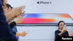 Attendees use new iPhone X during a presentation for the media in Beijing, China, Oct. 31, 2017. 
