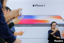 Attendees use new iPhone X during a presentation for the media in Beijing, China, Oct. 31, 2017.