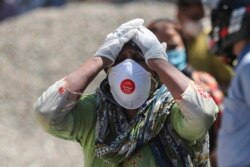 Reaksi seorang kerabat dari pasien COVID-19 yang meninggal di krematorium di Jammu, India, Minggu, 25 April 2021. (Foto: Channi Anand/AP)