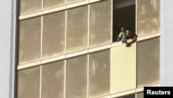 FILE - Workers board up a broken window at the Mandalay Bay Resort and Casino, where shooter Stephen Paddock conducted his mass shooting along the Las Vegas Strip, in Las Vegas, Nevada, Oct. 6, 2017.