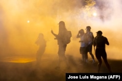 Demonstrators stand in a cloud of tear gas outside the White House on May 30, 2020 in Washington DC